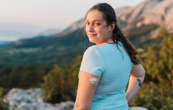 Woman with diabetes standing on top of the hill and looking at camera