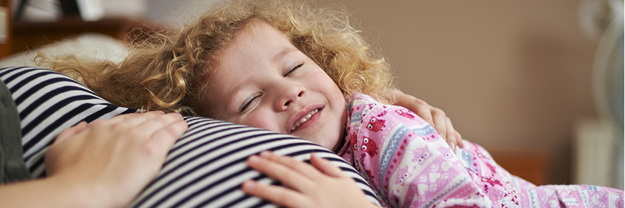 Child cuddling her mothers pregnancy baby bump