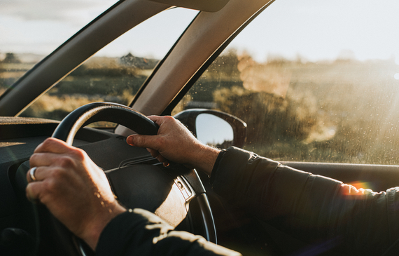 Hands holding steering wheel in a car