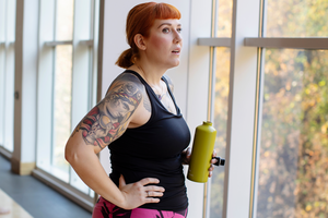 Woman in exercise outfit holding water bottle