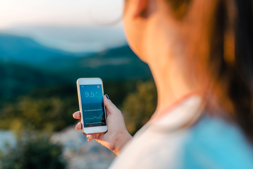Woman looking at glucose monitoring app on phone