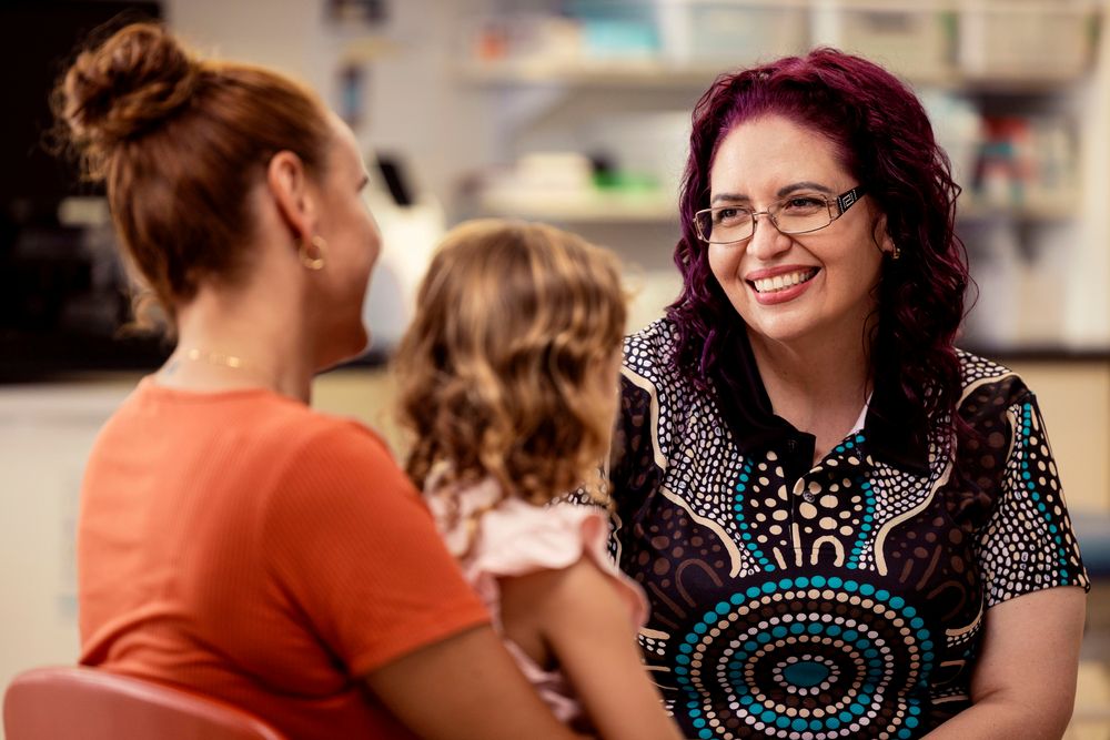Health professional talking to a mother and daughter