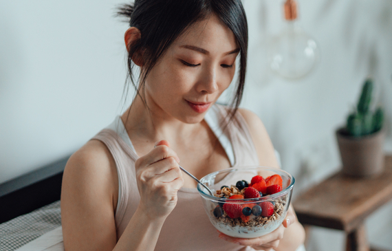 Woman eating a bowl of fruit