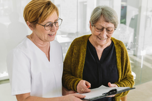 Nurse practitioner helping older patient filling out form