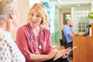 female patient chats to the doctor in the waiting room