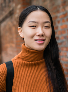 Asian woman standing outdoors in the street.