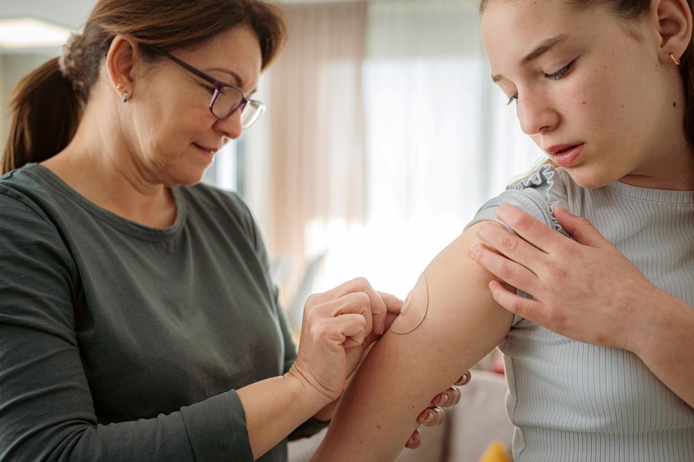Mother helping daughter with cgm device