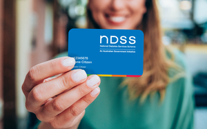 Woman holding a NDSS registration card - focus on foreground