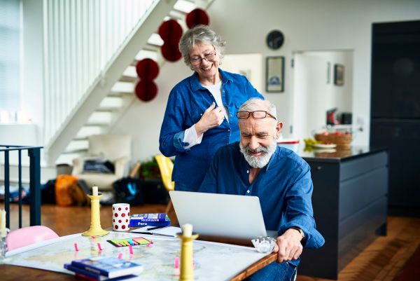 Older couple in living room, looking at laptop screen