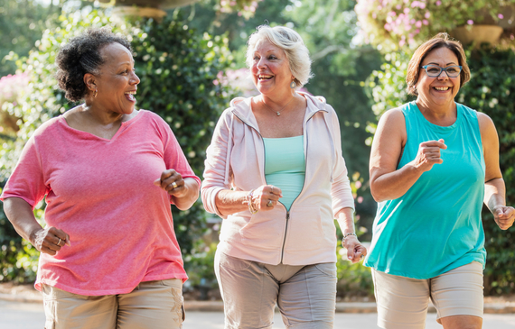 A group of older senior women, exercising together at a park,