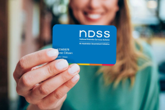 Woman holding out an NDSS card towards the camera