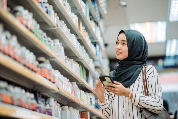 Woman standing in a pharmacy, looking at products on shelves