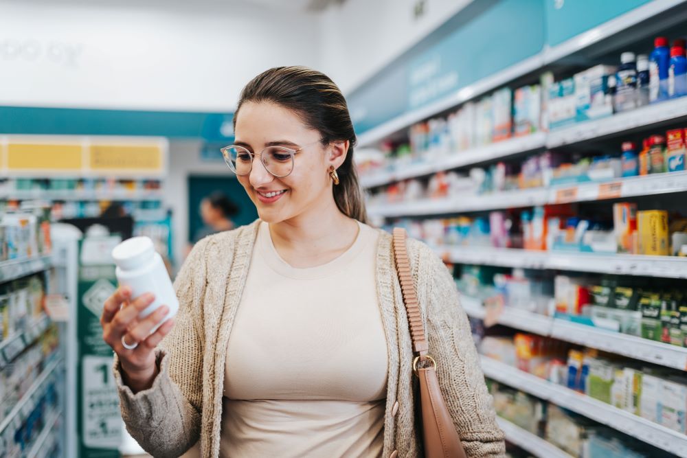 Woman shopping in a pharmacy, reading product label