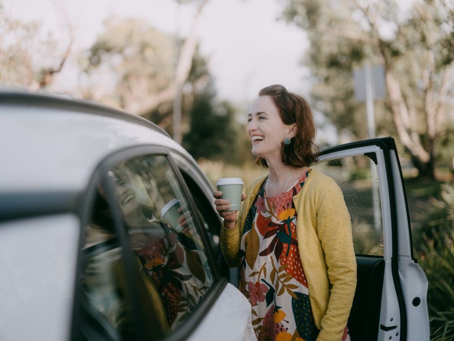 Woman standing next to car